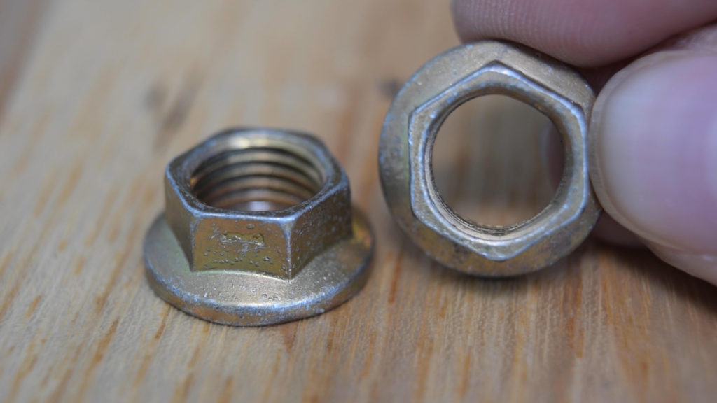 A locknut that shows a section has been purposely bent out-of-round to grip the threads.