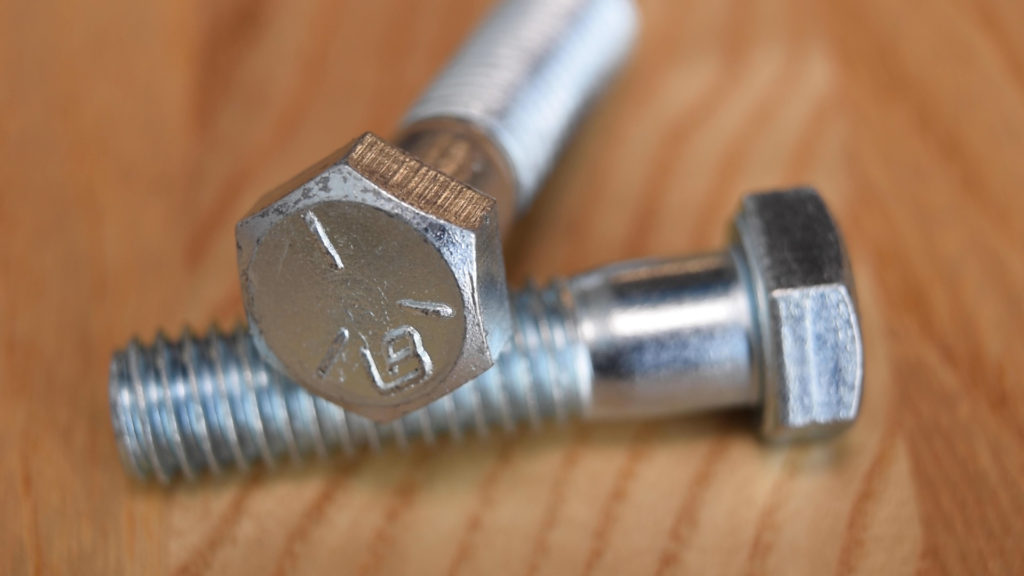 Two zinc-plated hex head screws, often called bolts.